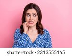Small photo of Portrait of worried stressed frightened pretty girl wear blue clothes biting finger look empty space isolated on pink color background
