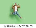 Small photo of Full size portrait of carefree active sporty guy jump demonstrate heave metal symbol empty space isolated on green color background