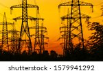 Small photo of high voltage post. High-voltage pylons against sunset background. Energy and industrialisation concept. Selective focus.