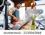 Small photo of Portrait of confident young salesman standing in butcher's shop