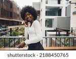 Black afro woman talking on mobile phone in the city