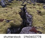 Small photo of Closeup view of deep fissure on rocky volcanic lava field covered by green moss near Grindavik, Reykjanes peninsula, Iceland on cloudy winter day.