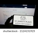 Small photo of Stuttgart, Germany - 02-06-2022: Person holding mobile phone with logo of British company St. James's Place plc on screen in front of business web page. Focus on phone display. Unmodified photo.