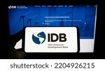 Small photo of Stuttgart, Germany - 09-07-2022: Person holding smartphone with logo of Inter-American Development Bank (IADB) on screen in front of website. Focus on phone display. Unmodified photo.