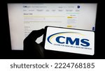 Small photo of Stuttgart, Germany - 09-22-2022: Person holding cellphone with logo of Centers for Medicare and Medicaid Services (CMS) on screen in front of webpage. Focus on phone display. Unmodified photo.