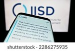 Small photo of Stuttgart, Germany - 04-01-2023: Mobile phone with website of think tank IISD institute on screen in front of logo. Focus on top-left of phone display. Unmodified photo.