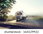 European truck speeding on freeway with colorful ambient colors and blurred motion.