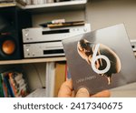 Small photo of Paris, France - Jan 21, 2024: A male hand delicately holds the cover of Lara Fabian's '6' SACD album, featuring melodic French-language songs, promising a musical journey