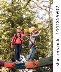 Small photo of Child playing on the playground. Balance beam and rope bridges. Go Ape Adventure. Hiking in the rope park girl in safety equipment. Adventure climbing high wire park. Child concept