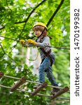 Small photo of Child concept. Rope park - climbing center. Hike and kids concept. Go Ape Adventure. Happy Little child climbing a tree
