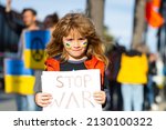 Child boy with poster with banner of russia conflict, military protest. America stand with Ukraine. Child with message Stop War. No war with Ukraine.