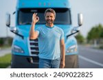 Small photo of Men driver near lorry truck. Man owner truck driver in t-shirt near truck. Handsome middle aged man trucker trucking owner. Transportation industry vehicles. Handsome man driver front of truck.