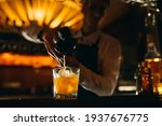 Small photo of The bartender squeezes citrus juice into a cocktail