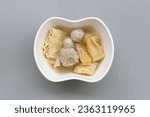 Small photo of Kway chap or kue chap, soup various ingredients such as braised pig offal, pig's tongue, pork rind, pork belly, meatballs and firm soya bean curds, served on bowl isolated on gray background, top view