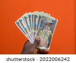 An African hand holding set of spread multiple naira notes, cash or nigerian currency