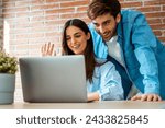 Small photo of Couple greet friends in video call at home at the table. Modern people in chat conference online. Small internet business. Saying hallo to parents remote. Man and woman using laptop in indoor leisure