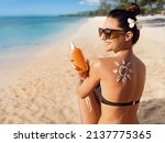 Beauty Woman Applying Sun Cream on Tanned Shoulder In Form Of The Sun. Sun Protection.Sun Cream. Skin and Body Care. Girl Using Sunscreen to Skin. Female Holding Suntan Lotion