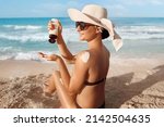 Small photo of Sun Protection. Skin and Body Care. Girl Using Sunscreen to Skin. Beautiful Woman in Bikini Applying Sun Cream on Tanned Shoulder.