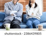 Young Asian couple thinking (fighting) while sitting on the sofa
