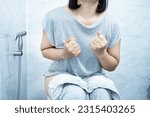 Small photo of woman have problem with chronic constipation, bowel movement is painful sitting in toilet
