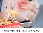 Small photo of woman suffering from acid reflux , heartburn after over eating junk food, pizza and burger