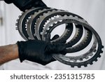 A man holds automatic transmission clutches in his hands. Gearbox replacement, repair work in a car service or garage. Assembly of automatic transmission, disassembly of parts. 
