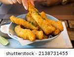 Small photo of Fresh fried Brazilian tilapia fish strips with lime and tartar sauce known as isca de peixe. Traditional Brazilian appetizer. Selective focus.