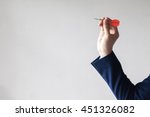 Businessman holding a dart aiming at the target - business targeting, aiming, focus concept.