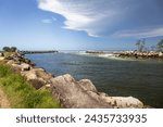 Small photo of Big rocks and ominous storm clouds in sky over water at breakwall on Wooli Wooli River