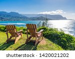 lounging chairs overlooking Hanalei Bay and the Na Pali coast Princeville Kauai Hawaii USA in the late afternoon sun