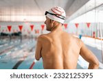 Small photo of Portrait of an adult swimmer with an amputated arm poses on his back in a heated indoor pool. Concept of disabled athletes, swimmers with an amputated arm. Inclusive sport.Improvement in sport.