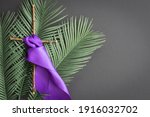 cross with purple sash and palms on black background