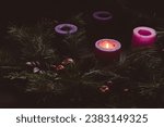 Rustic advent wreath with one candle lit in a dark room with copy space