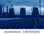 Small photo of road with car passing in succession with heat power plant at sunset in big city toned in trendy pantone Classic Blue color of the Year 2020