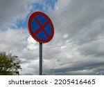 Close-up photo of no parking traffic sign with the cloudy sky in the background