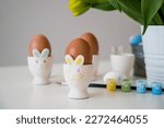 Small photo of Easter greeting card eith pastel paint,eggs in bunny holders etc