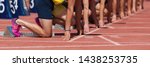 Small photo of Group of male track athletes on starting blocks.Hands on the starting line.Athletes at the sprint start line in track and field
