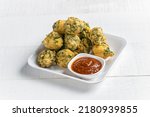 Small photo of Fulwada Bhajiya. Methi bhajiya. Methi gota, Methi pakoda indian gujarati special snack food with chutney dip. Close up monsoon special gujarati methi bhajiya. Fulvada.