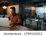 Small photo of Business working online with a laptop while sitting alone at his desk in a quiet office after hours