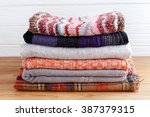 Winter fashion clothing stack with scarf gloves and blanket