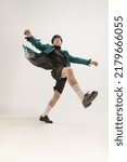 Small photo of Portrait of young expressive man in stylish outfit posing isolated over grey studio background. Autumn look. Concept of modern fashion, art photography, style, queer, uniqueness, ad