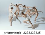 Group of young girls, ballet dancers performing, posing isolated over grey studio background. Circle movements. Concept of art, beauty, aspiration, creativity, classic dance style, elegance