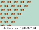 Trendy pattern made  of chocolate chip cookies on bright green mint background. Minimal concept, diagonal copy space.