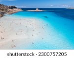 Small photo of Aerial view of famous La Pelosa beach at sunny summer day. Stintino, Sardinia island, Italy. Top view of sandy beach, swimming people, clear blue sea, old tower and sky with clouds. Tropical seascape