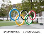 Small photo of TOKYO, JAPAN - JANUARY 6, 2021 : The Olympic symbol monument and New National Stadium for Tokyo 2020 Olympic Games. The events were postponed to summer 2021 due to the COVID-19 pandemic