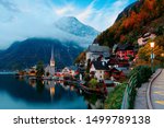 Fall scenery of Hallstatt at dawn, a peaceful lakeside village & a UNESCO heritage site in Salzkammergut region of Austria, with beautiful reflections in lake water & majestic mountains in background