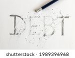 Small photo of Erasing debt. Debt written on white paper with a pencil, partially erased with an eraser. Symbolic for erasing debt.