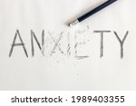 Small photo of Erasing anxiety. Anxiety written on white paper with a pencil, partially erased with an eraser. Symbolic for overcoming anxiety or treating anxiety.