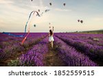 young woman running on lavender field with kite, freedom concept
