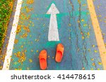 Orange shoe on the way keep moving to forward.  Asphalt road and direction arrow sign. setup to success concept. Choosing your Choices. 